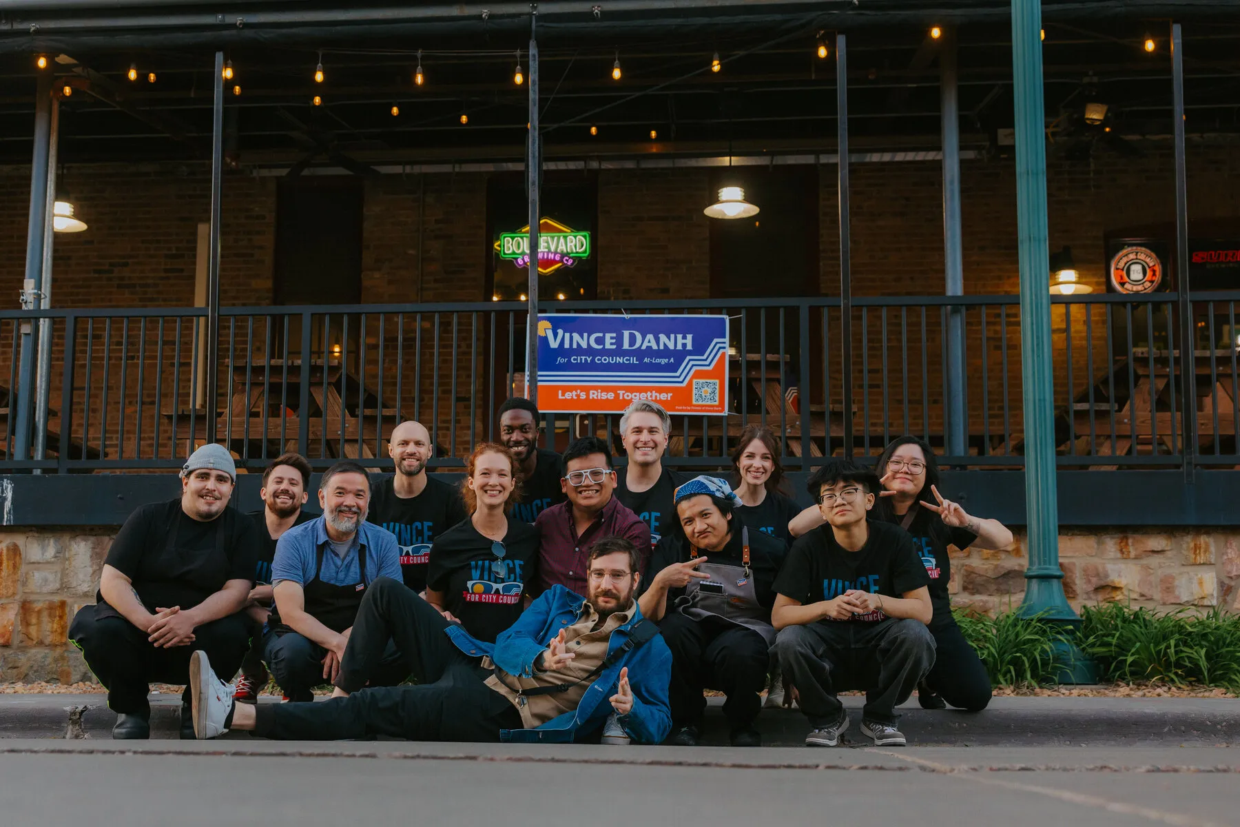 Vince Danh and the campaign team outside Boulevard Brewing Co. with a Vince Danh for City Council, Let's Rise Together sign